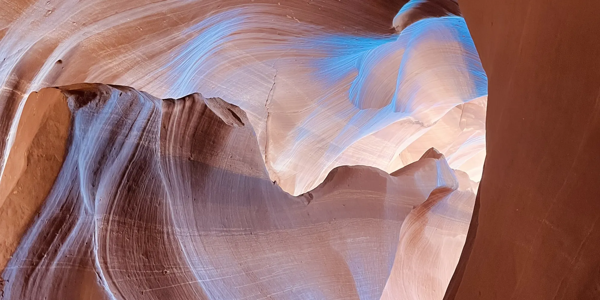 Blue and orange light on the curved walls of a slot canyon
